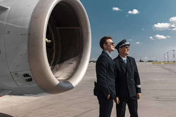Knappe volwassen mannen staande in de buurt van de motor van het vliegtuig — Stockfoto