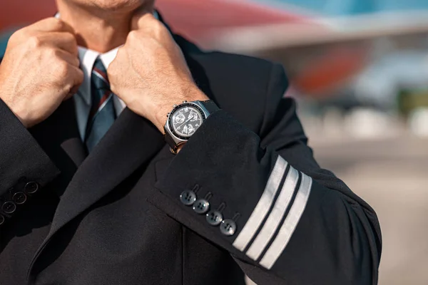 Zavřít Kavkazský pilot narovnávat si sako před letem — Stock fotografie