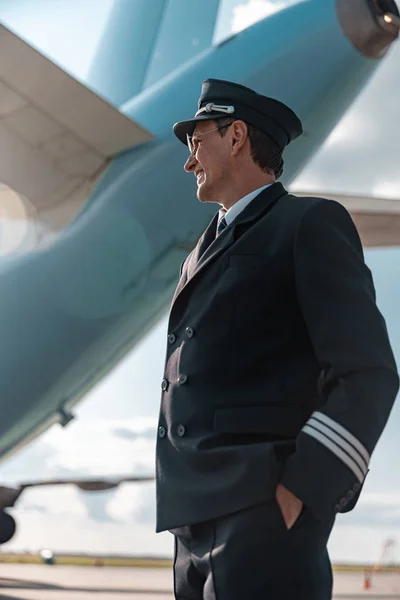 Взрослый пилот в форме отдыхает на открытом воздухе в аэропорту — стоковое фото