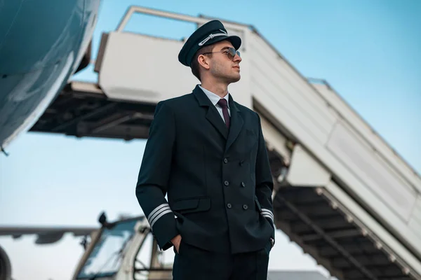 Красивий молодий чоловік стоїть біля літаків — стокове фото