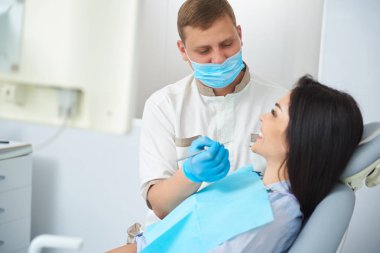 Erkek diş hekimi kadın dişlerinde boşlukları tanımlayan