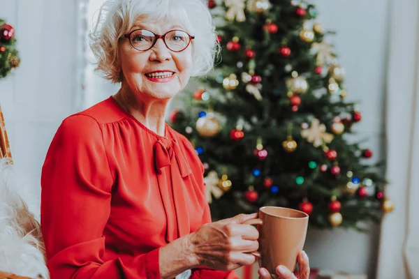 Lachende Senior vrouw geniet van een warm drankje — Stockfoto