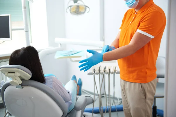 Dentista masculino em pé perto do paciente no quarto — Fotografia de Stock