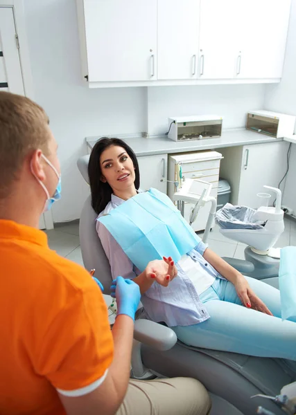 Linda senhora falando com dentista na clínica — Fotografia de Stock