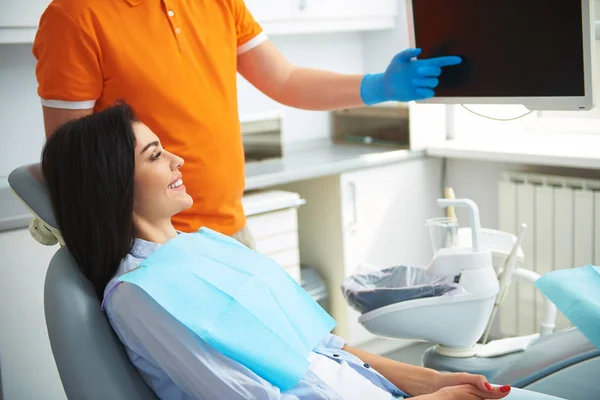 Smiling lady looking on the screen in dentistry — Stock Photo, Image
