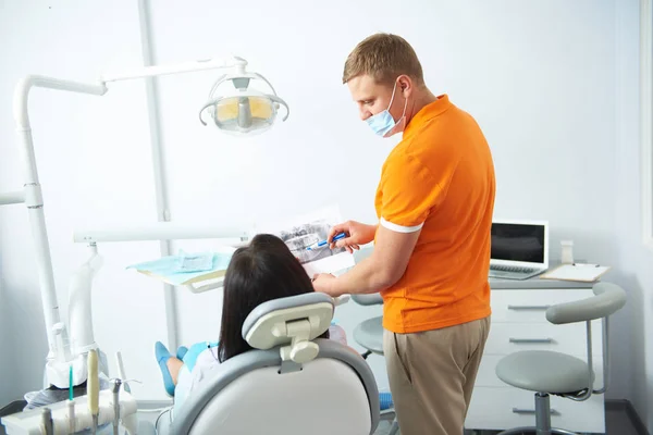 Male stomatologist explaining results of x-ray to female — Stock Photo, Image