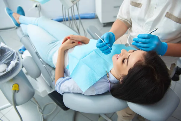 Odontólogo masculino examinando dientes de mujer feliz — Foto de Stock