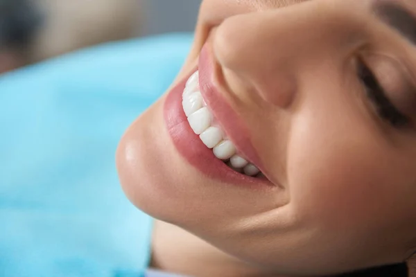 Mujer feliz con sonrisa blanca como la nieve en la clínica dental — Foto de Stock
