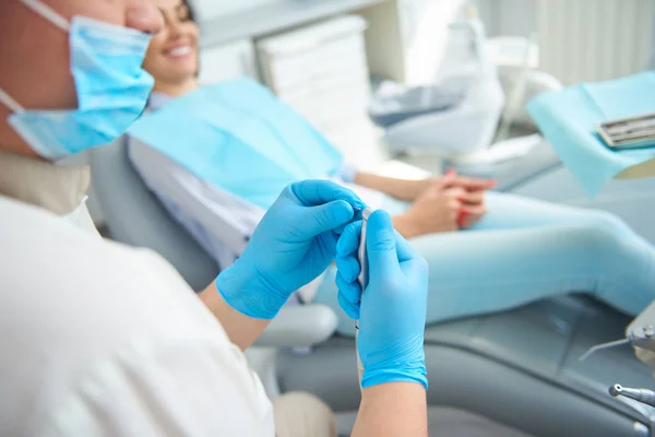 Красивий чоловічий стоматолог, що сидить біля пацієнта жінки — стокове фото