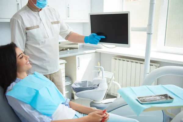 Male dentist in gloves holding hand near screen — Stock Photo, Image