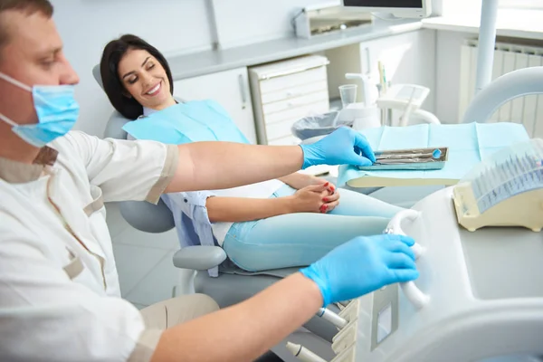 Happy young woman sitting at dental office — Stock Photo, Image