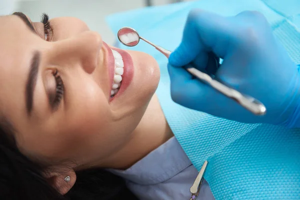 Bastante joven hembra está visitando dentista y sonriendo — Foto de Stock