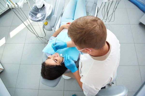 Encantadora joven dama está visitando dentista masculino — Foto de Stock