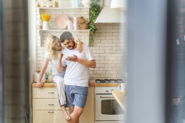 Sakallı adam elinde bir tabak tutuyor.