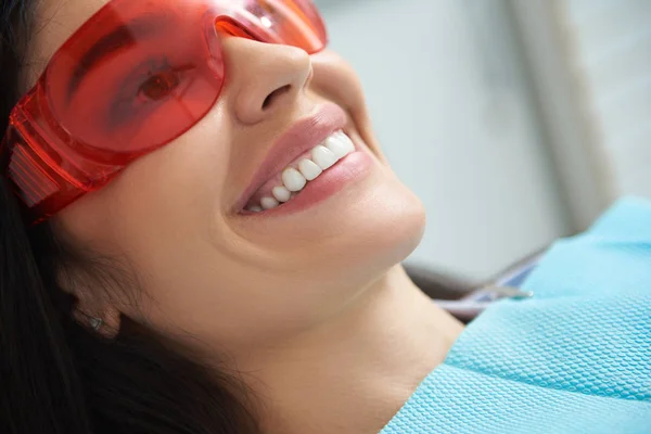 Усміхнена дама використовує захисні окуляри в стоматологічній кімнаті — стокове фото