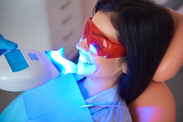 Mulher feliz com os olhos fechados na cadeira do dentista — Fotografia de Stock