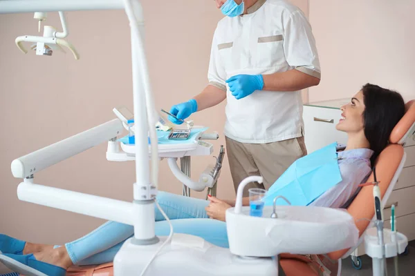 Profissional dentista masculino está segurando instrumentos dentários — Fotografia de Stock