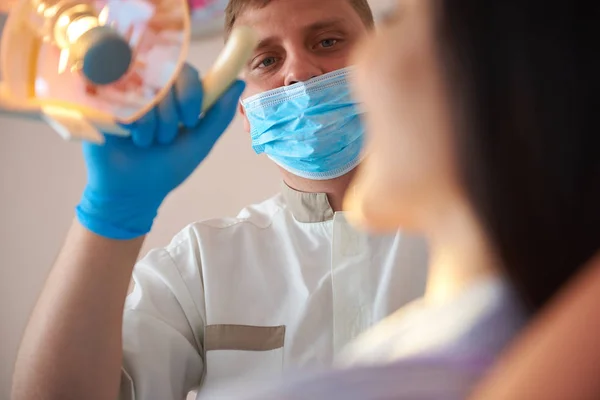 Красивий чоловічий стоматолог дивиться на молоду жінку — стокове фото