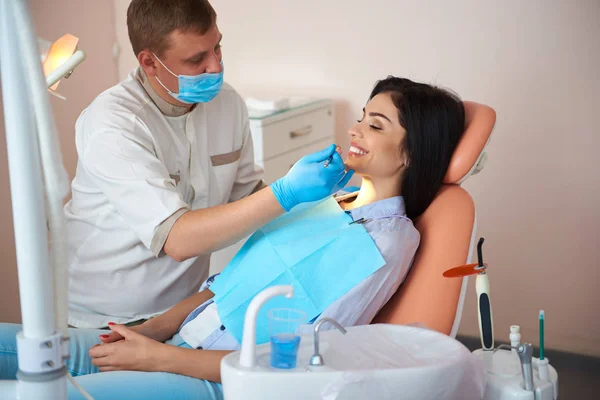 Hermosa mujer sonriendo durante el chequeo en la clínica dental —  Fotos de Stock