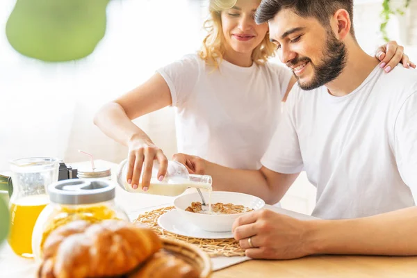 Hustru hälla mjölk i en tallrik med cornflakes — Stockfoto