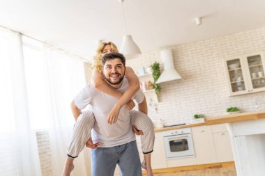 Sakallı adam kadını sırtında tutuyor