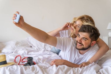 Gülümseyen sakallı adam cep telefonu tutuyor