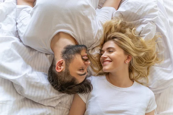 Ευτυχισμένος άντρας μια γυναίκα ξαπλωμένη στο κρεβάτι — Φωτογραφία Αρχείου