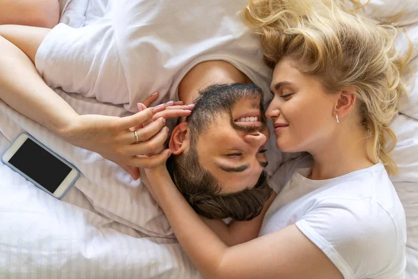 Ευτυχισμένο ζευγάρι αγκαλιάζει τρυφερά στο κρεβάτι — Φωτογραφία Αρχείου