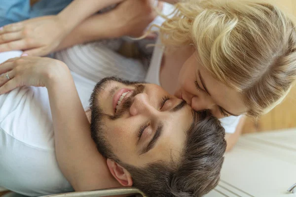 Гарненька молода жінка цілує бородатого чоловіка — стокове фото