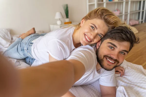 Mosolygó férfi és nő vesz selfie a hálószobában — Stock Fotó