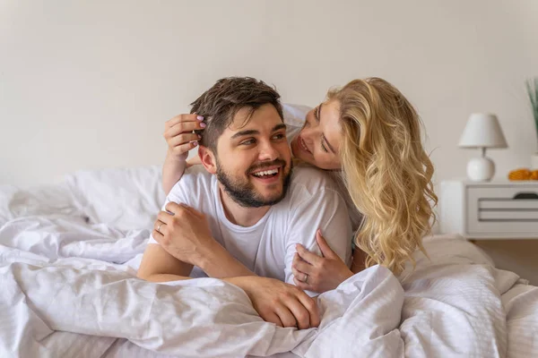 Jonge vrouw is knuffelen vriendje in de slaapkamer — Stockfoto