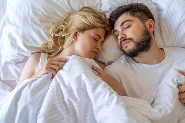 Молодая влюбленная пара спит в постели — стоковое фото