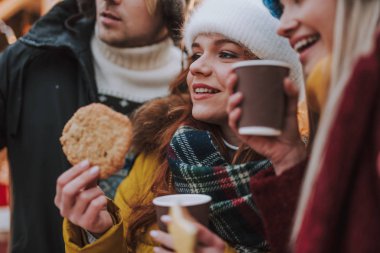 Arkadaşlarının yanında duran mutlu genç kadın