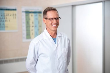 Mutlu olgun doktor uzakta kapalı bakıyor