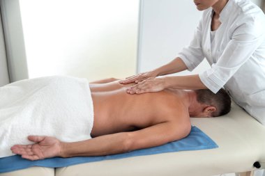 Masör bir hastanın sırtını ovuşturarak