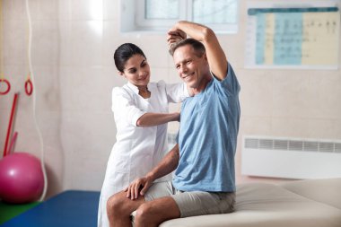 Gülümseyen erkek patien özel egzersizler yapıyor