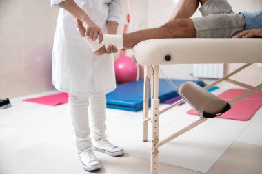 Kadın doktor erkek için bacak ligasyon yapıyor