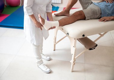 Kadın doktor hasta için bir bandaj kullanıyor