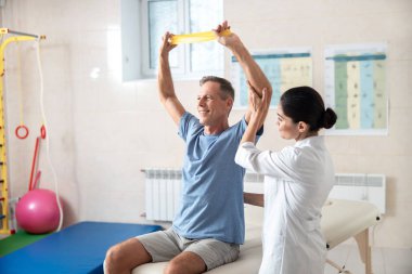 Mutlu adam fitness lastik bant ile egzersizleri yapıyor