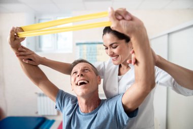 Mutlu adam rehabilitasyon egzersizleri germe yapıyor