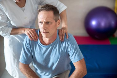 Doktor hastanın omuzlarında el ele tutuşuyor