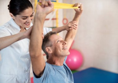 Gülümseyen kadın doktor egzersizleri yapmaya yardımcı