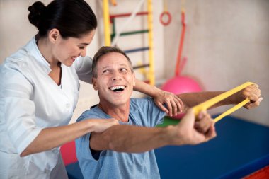 Fitness için lastik bant ile egzersizler yapan mutlu adam