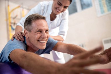 Mutlu olgun hasta rehabilitasyon egzersizleri yapıyor