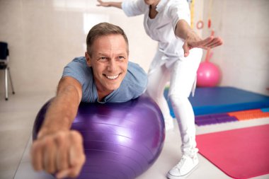 Bir fintes topu üzerinde yatan mutlu olgun adam