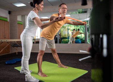 Erkek olgun hasta germe egzersizleri yapıyor