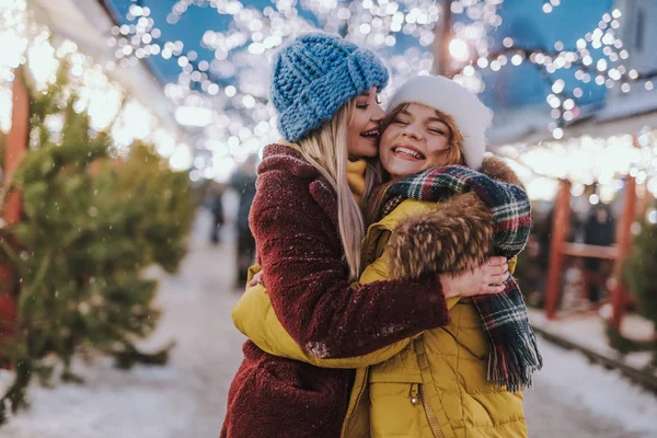 Dos hermosas chicas caminando por el mercado de Navidad — Foto de Stock