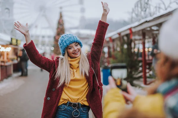 Çekici sarışın kız çekim sırasında iki kolunu yükselterek