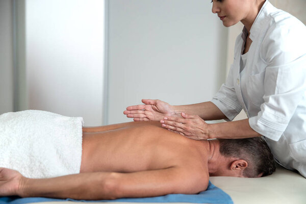 Женщина-медик делает массаж спины в больнице
