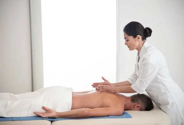 Médico feminino está fazendo massagem para o homem — Fotografia de Stock